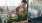 woman tends to her plants on balcony