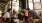 group of coworkers laugh and talk around coffee table in bright workspace